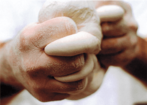 A close-up of hands squeezing dough